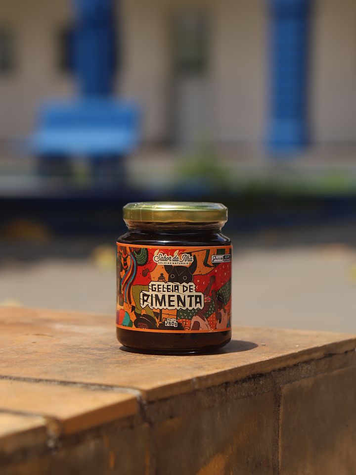 Pote de geleia de pimenta sobre um banco de madeira