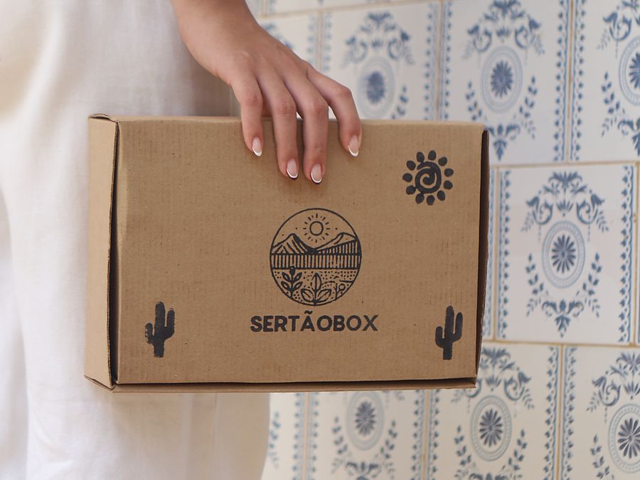 Pessoa segurando a caixa SertãoBox fechada